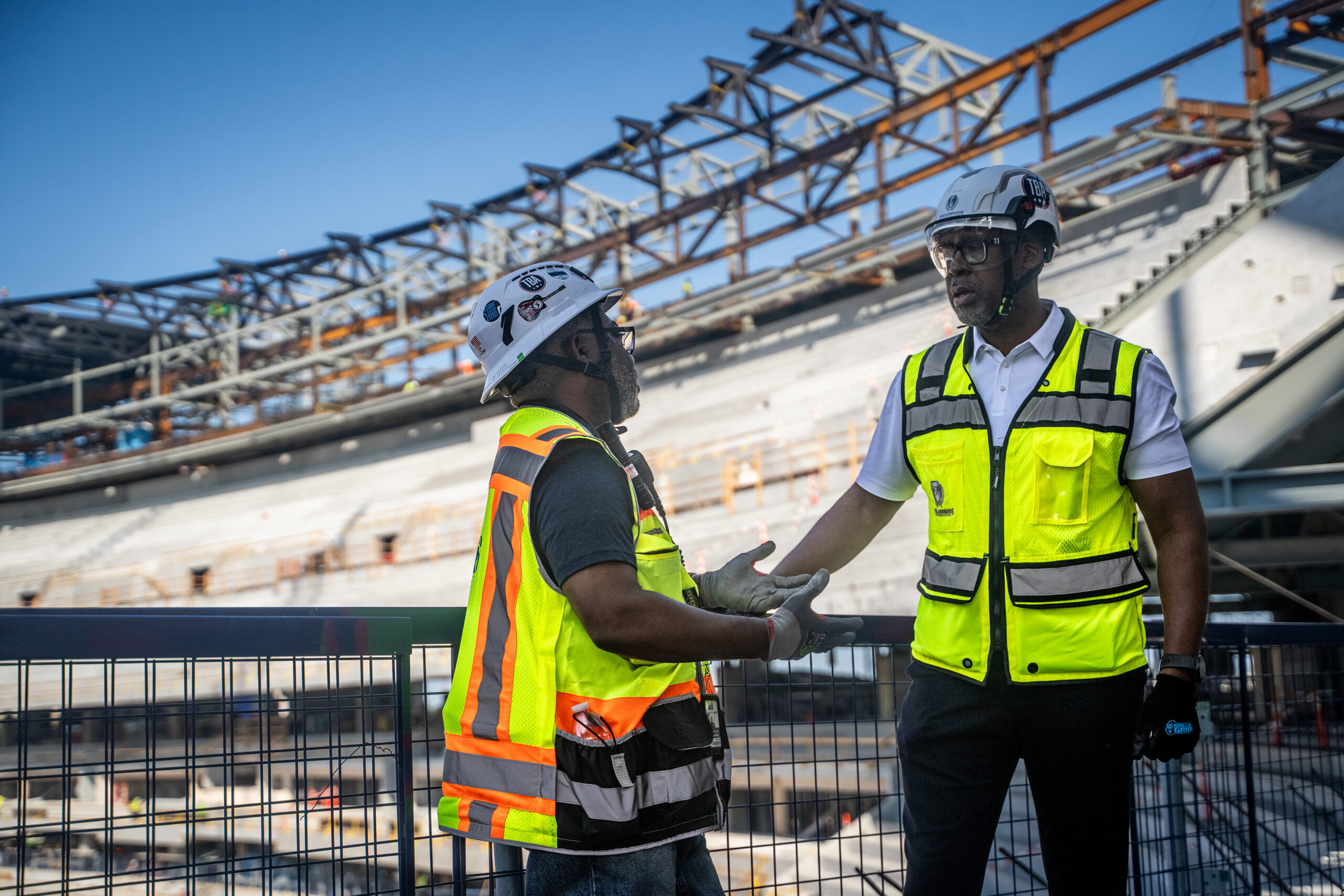 Two construction workers in conversation at a job site.